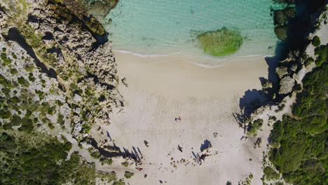 Aerial-view-over-people-in-Salmon-Bay,-Rottnest-Island,-Australia--forward-birds-eye,-drone-shot