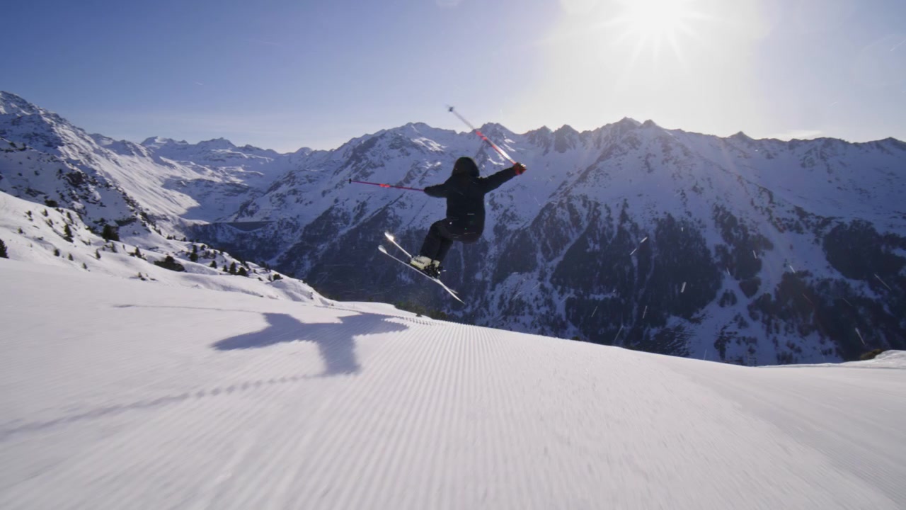 Skier carving groomed pistes at high speed in Nendaz, part of the 4 Vallées ski area in the Swiss Alps. Elite alpine skiing with powerful snow spray and precision technique.