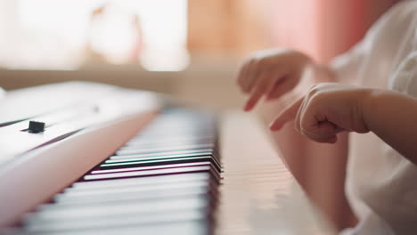 Niño-Pequeño-Toca-El-Piano-Con-Los-Dedos-Sobre-Fondo-Borroso