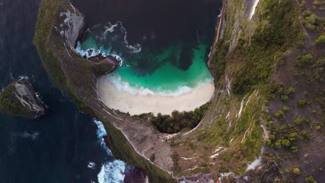 aerial drone view captures kelingking beach at golden hour as the sunlight highlights the blue ocean and dramatic cliffs forming a breathtaking coastal scene in nusa penida.