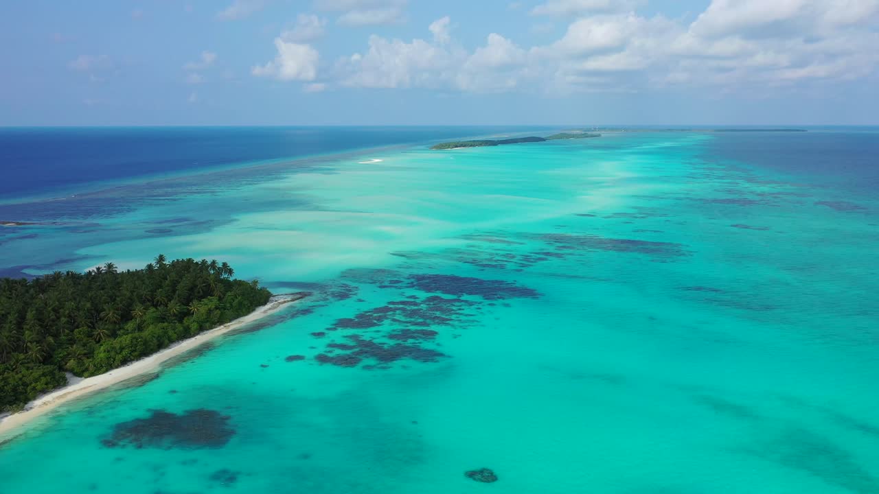 Paradise gateway of tropical islands with large turquoise lagoon between, in the middle of deep blue ocean on a bright sky with clouds in Maldives