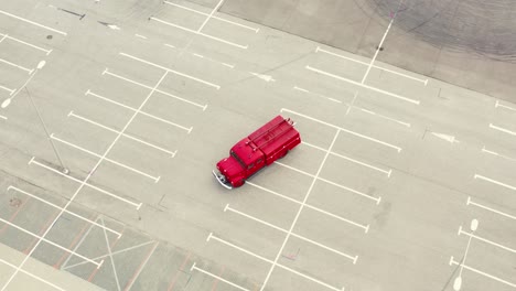 vintage red vehicle, old fire engine equipped with tools for firefighting tasks, driving on empty parking