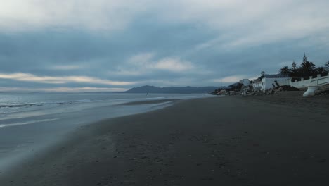 Aerial-view-of-Marbella-coastline-on-a-dark-cloudy-day,-moving-into-the-sea