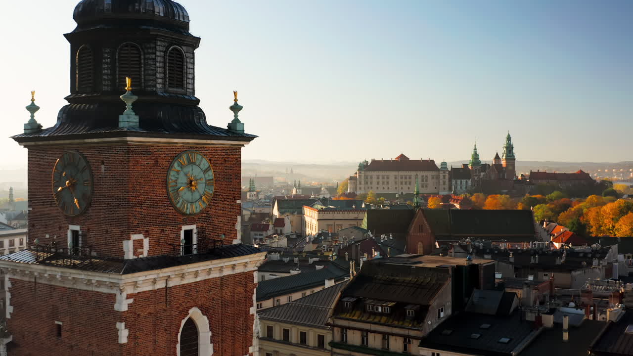 Panorama of Old Town in Krakow, Poland.View on clock on the town hall tower, the Wawel castle, Grodzka street and tenement houses with autumn colors at morning