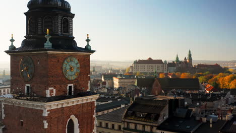 panorama of old town in krakow, poland.view on clock on the town hall tower, the wawel castle, grodzka street and tenement houses with autumn colors at morning
