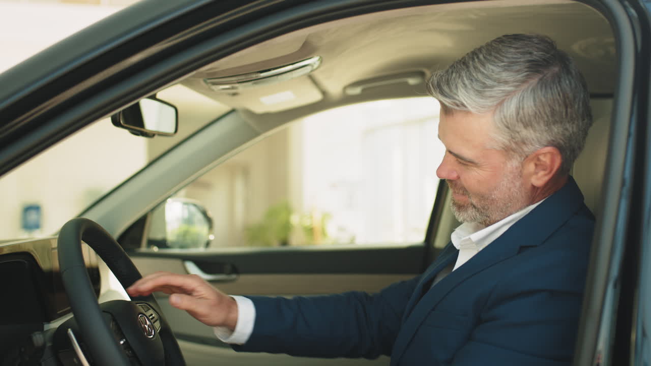 hombre examinando un coche nuevo en un concesionario
