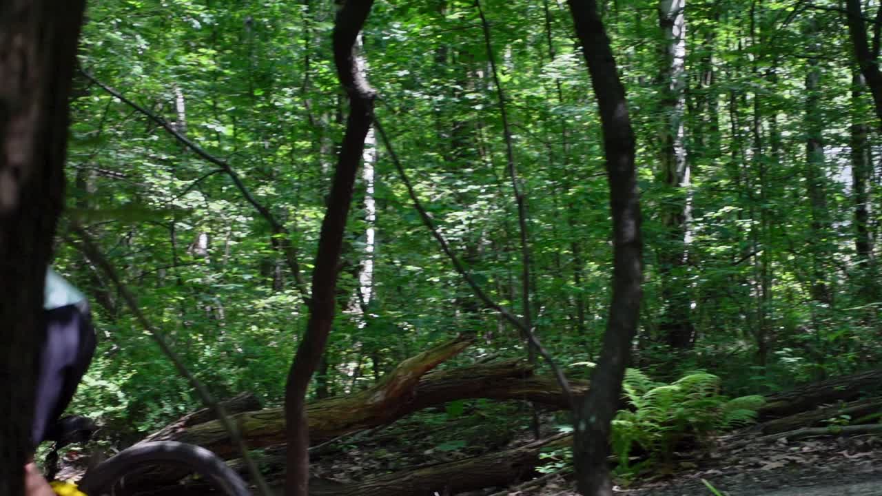 늦은 움직임으로  ⁇ 은 날에 숲 속의 트레일에서 전기 자전거에 뛰어드는 성인 남성의 후속  ⁇ 이 확대되어 자전거에 초점을 맞추고 있습니다.