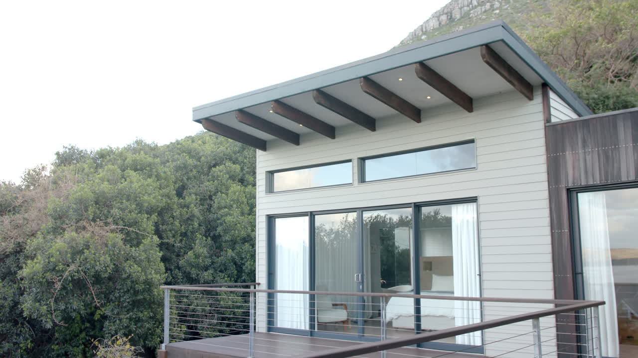 vista general de la casa con grandes ventanas y balcón, cámara lenta