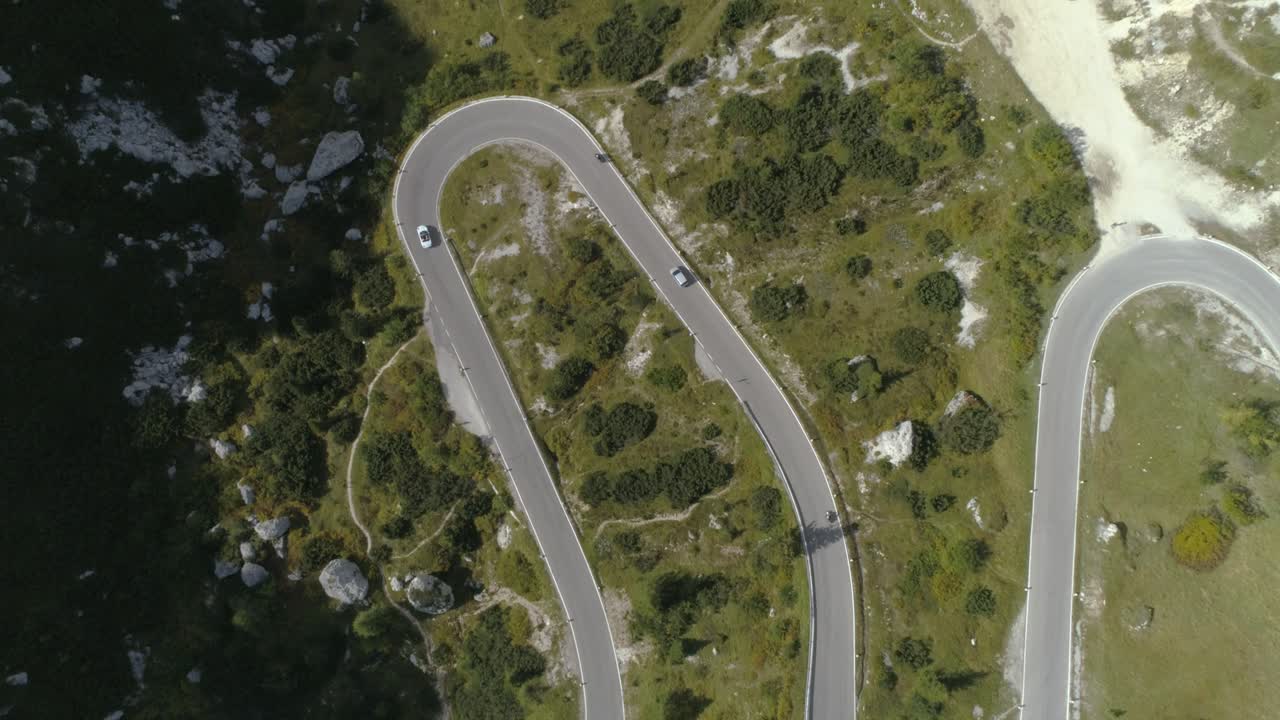 vista aérea de un pájaro siguiendo un coche en una carretera de montaña en los dolomitas italianos