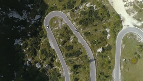 aerial birdview following a car on a mountain road in the italian dolomites