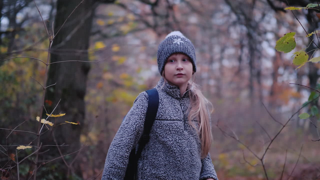 una niña camina por el bosque al anochecer un niño perdido en el bosque