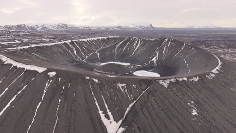 hverfjall's symmetrical tephra cone crater with snow patches near lake mývatn. hverfjall, iceland