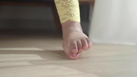 child's foot on wooden floor