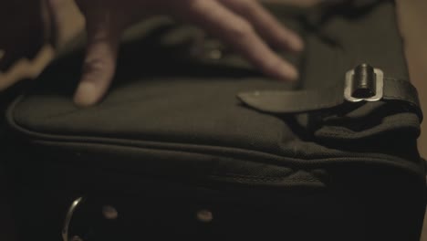 4k shot of opening a zipper of a retro camera bag in warm light