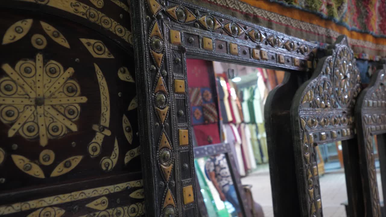Close up view of beautifully decorated with filligree work on the mirror frames placed in an antique shop by the side of a road on a busy morning.