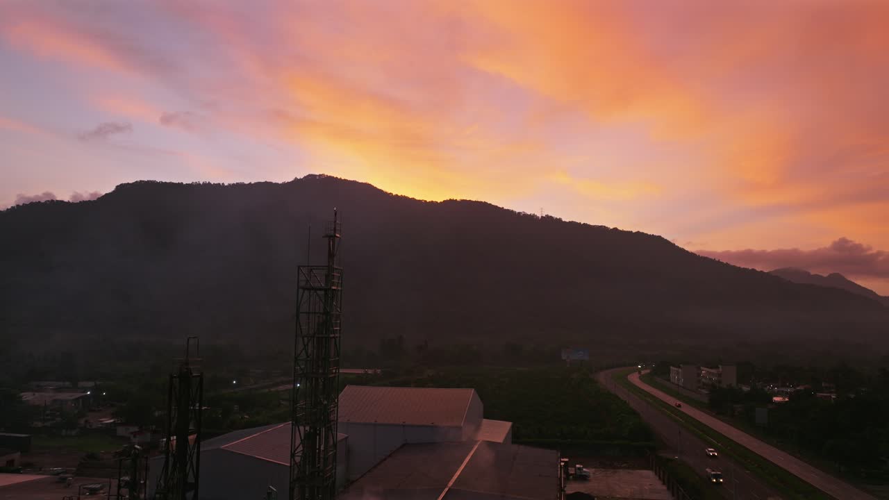 도미니카 공화국 빌라 알타그라시아의 도로를 따라 아름다운 일몰을 배경으로 한 산업 건물 현장