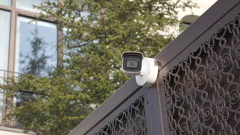 security camera mounted on a metal gate outside of a building