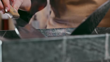 barista's skillful hands roasting coffee beans with flames on a granite plate, using a hand shovel