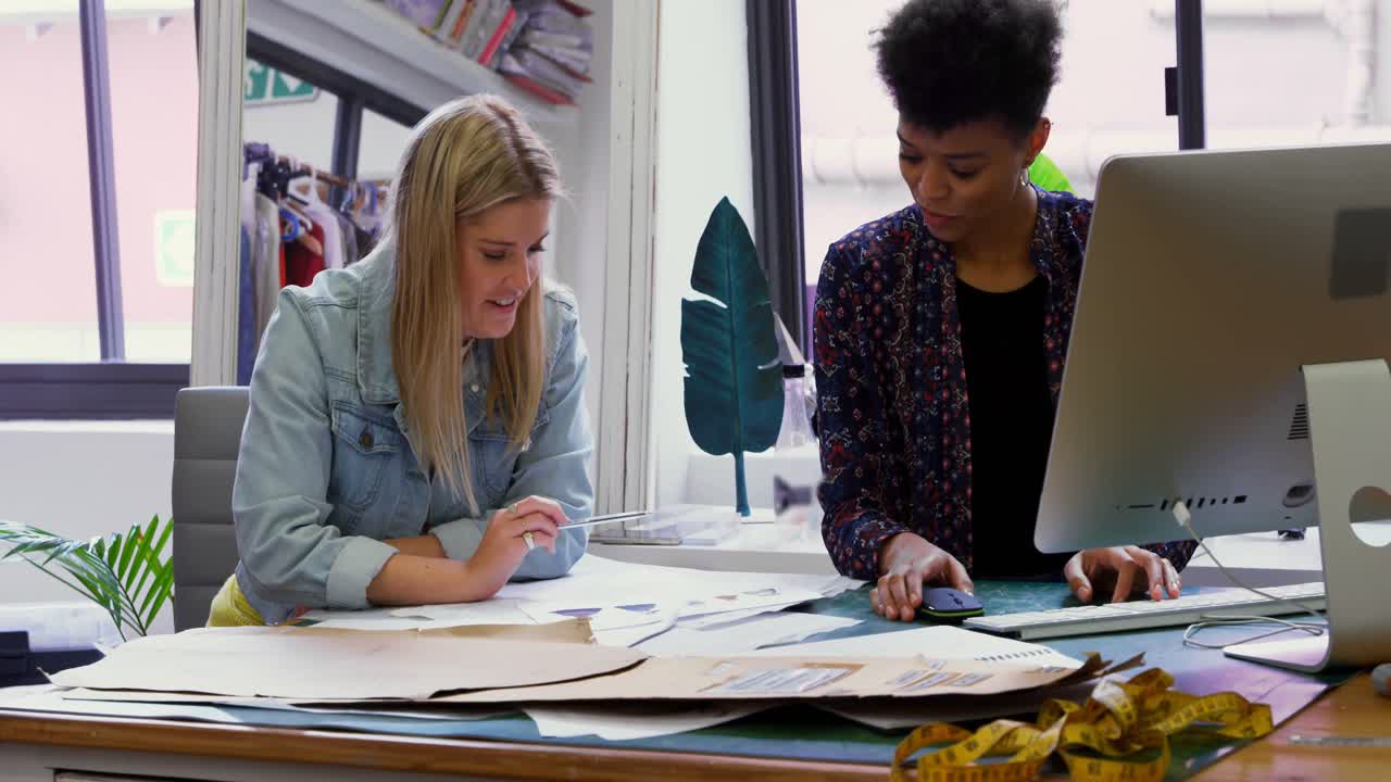 Fashion designers discussing at desk 4k