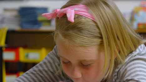 Vista-Frontal-De-Una-Colegiala-Caucásica-Durmiendo-En-El-Escritorio-En-El-Aula-De-La-Escuela-4k