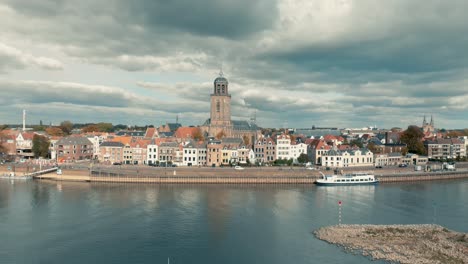 aerial view of dutch medieval city deventer slowly panning up revealing the whole city under a dramatic overcast cloudy sky