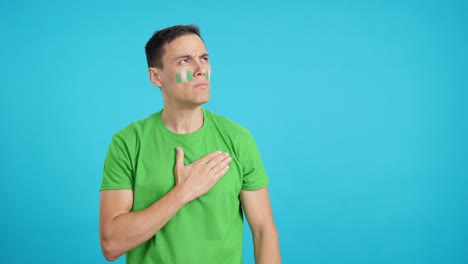 man listening to the nigeria national anthem with solemnity