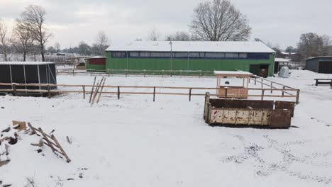 aerial view of a snowy farm with horses in northern germany