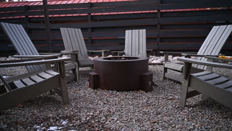 poly lumber patio chairs arranged around gas fire pit during the winter, pan