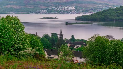 cinematic timelapse of scottish lake sunset during golden hour with lake village in background