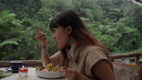 woman enjoying a meal outdoors in a peaceful, lush, natural environment