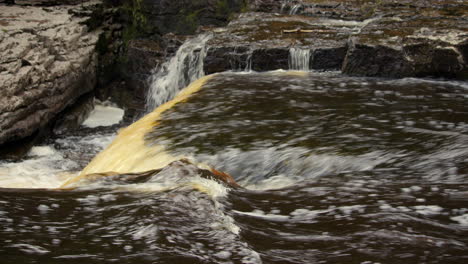 side shot of the river ure going over the lower falls at aysgarth falls on the river ure, yorkshire dales