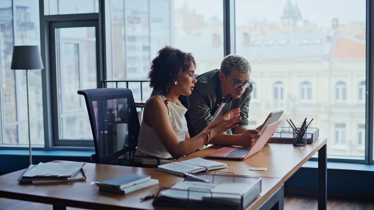 Colleagues brainstorming project office. Man woman discussing tablet window.