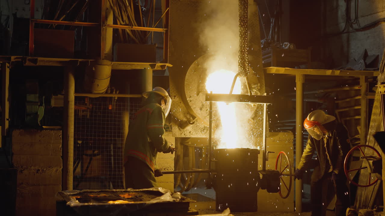 Foundry workers in action pouring molten steel with fiery sparks