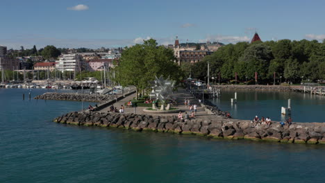 Aerial-of-people-relaxing-on-pier-at-lake-Geneva-near-the-city-of-Lausanne,-Switzerland