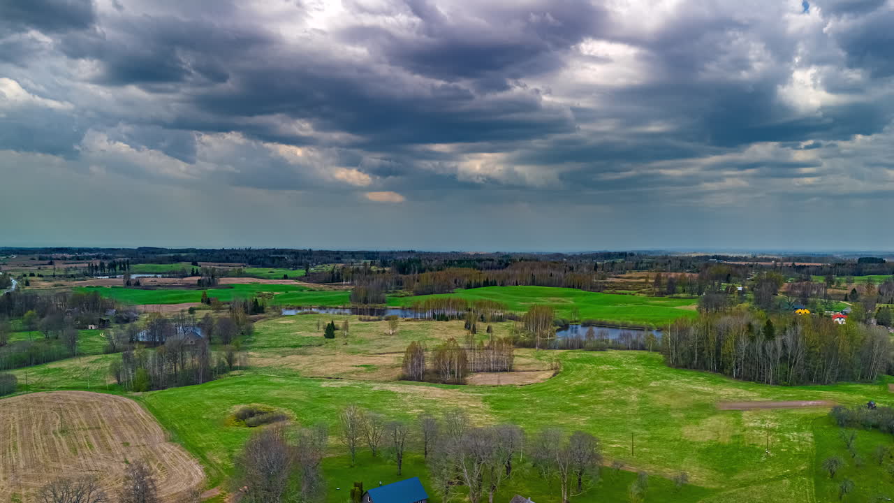 Cloudscape Over Countryside With Small Ponds On Grass Fields. Timelapse