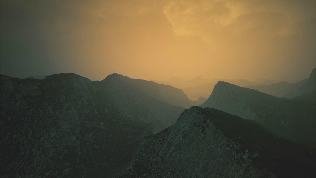 멀리서 황금빛 하늘 아래의 안개가 가득한 산들