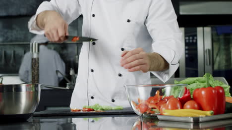 Chef-cooking-salad-in-kitchen
