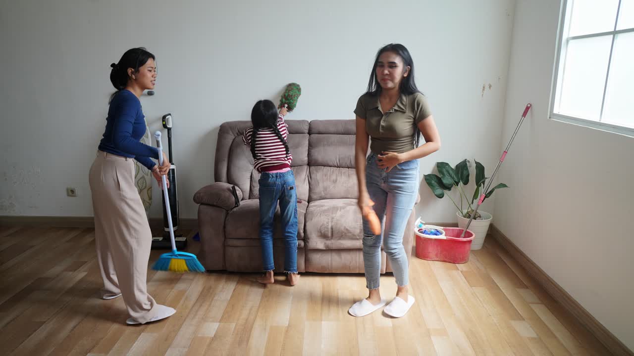 Happy Asian Family Stacking Hands And Cheering Before Cleaning Home Doing Housework Together