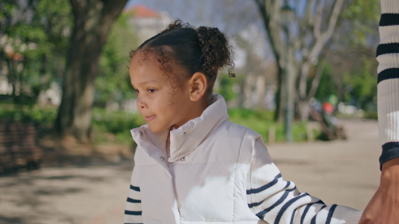 девушка, держащая руку неизвестной женщины, гуляющая в парке вблизи. семейный уик-энд