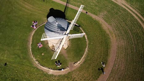 landmark chesterton historic wooden sail windmill aerial orbit birdseye left view above tourists in rural english countryside