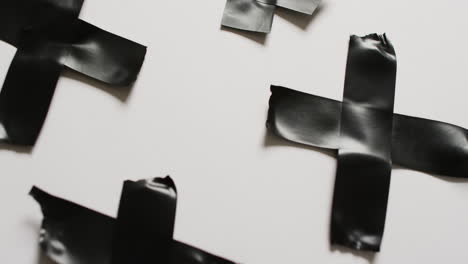 video de primer plano de la cinta negra formando cruces sobre un fondo blanco