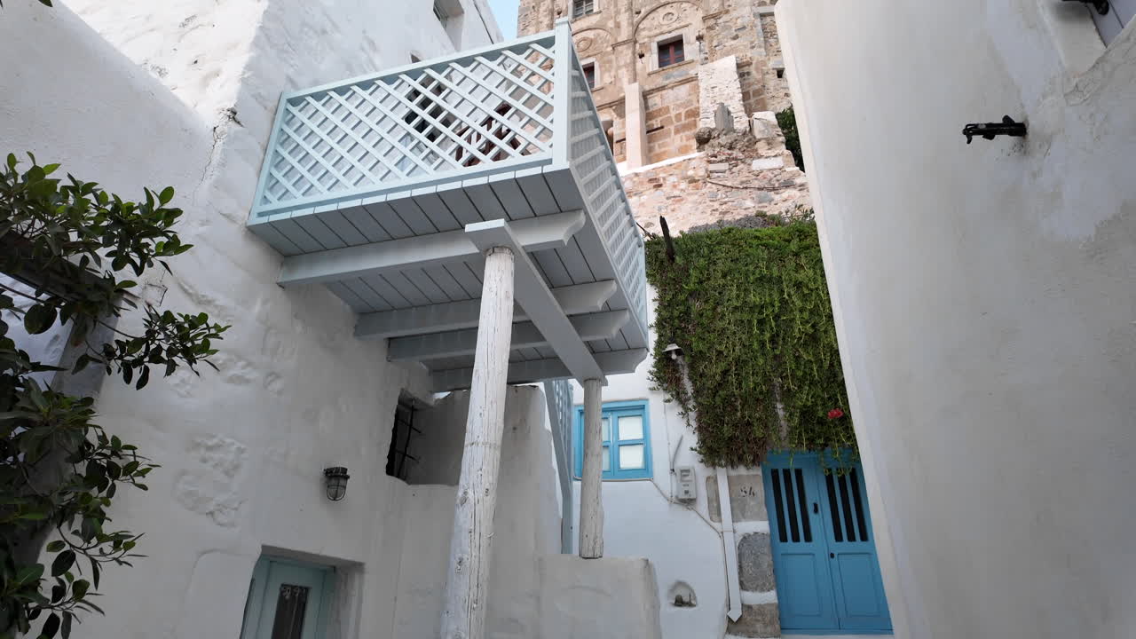 Greece, Astypalea Island, Narrow streets of the old castle area. Camera is tilting up from the narrow street towards to the entrance of the castle and the old castle wall. Beautiful old street shot.