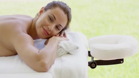 mujer sonríe a la cámara mientras está en el spa