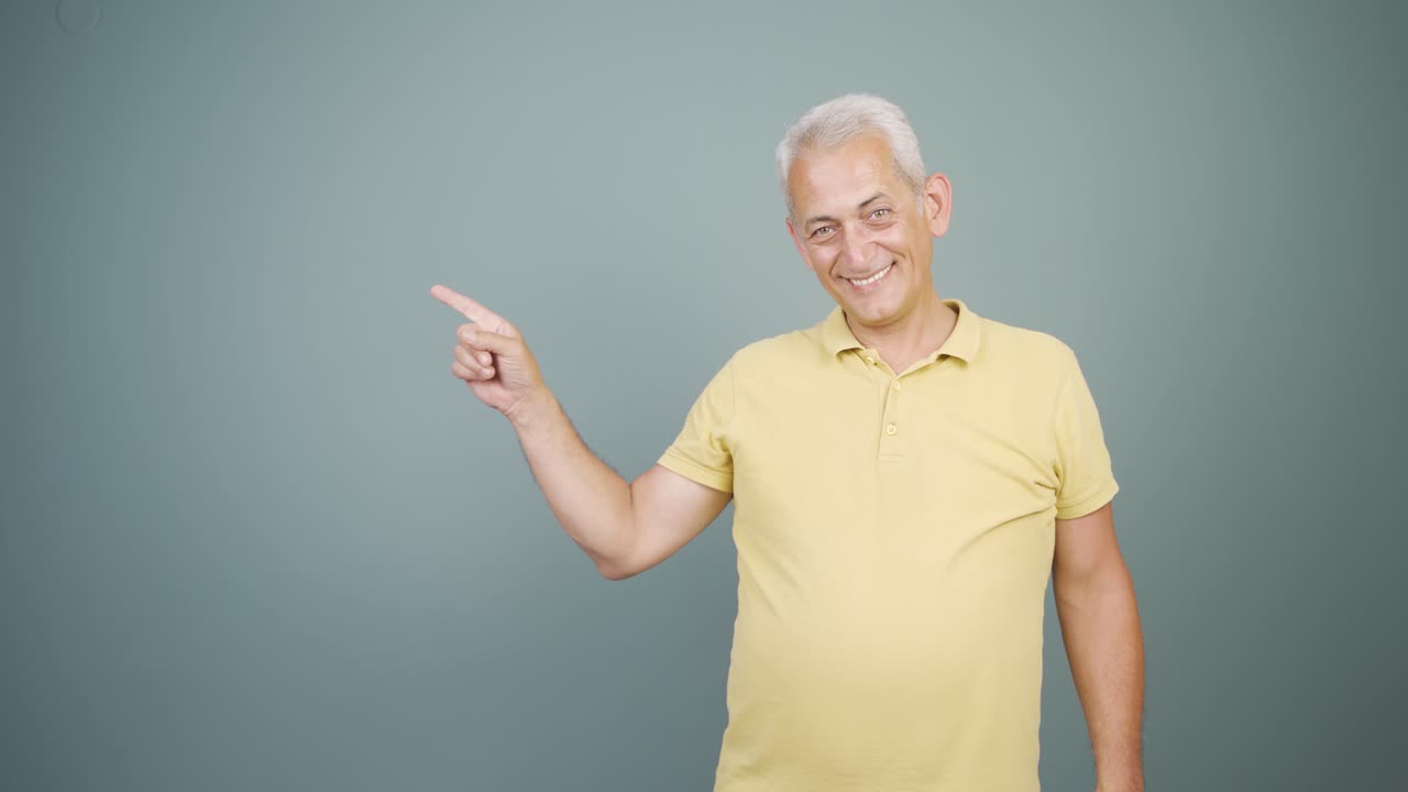 Manden, der promoverer, peger til siden og griner