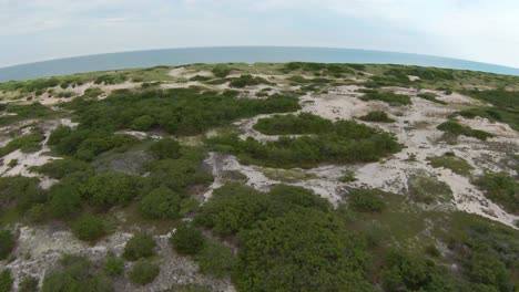 Toma-De-Drones-Fpv-Del-Increíble-Paisaje-Con-Follaje,-Dunas-De-Arena-Blanca-Y-Senderos-Que-Conducen-Al-Océano-Atlántico-En-El-Horizonte