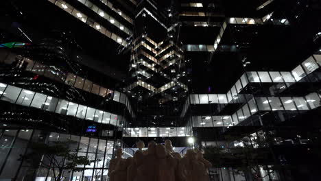 beautiful city landscape at night - modern buildings of richter llp tower with the illuminated crowd sculpture on the foreground during the coronavirus in downtown montreal, quebec, canada