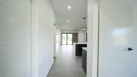 dolly along hallway to newly built minimal empty open plan kitchen dining and lounge