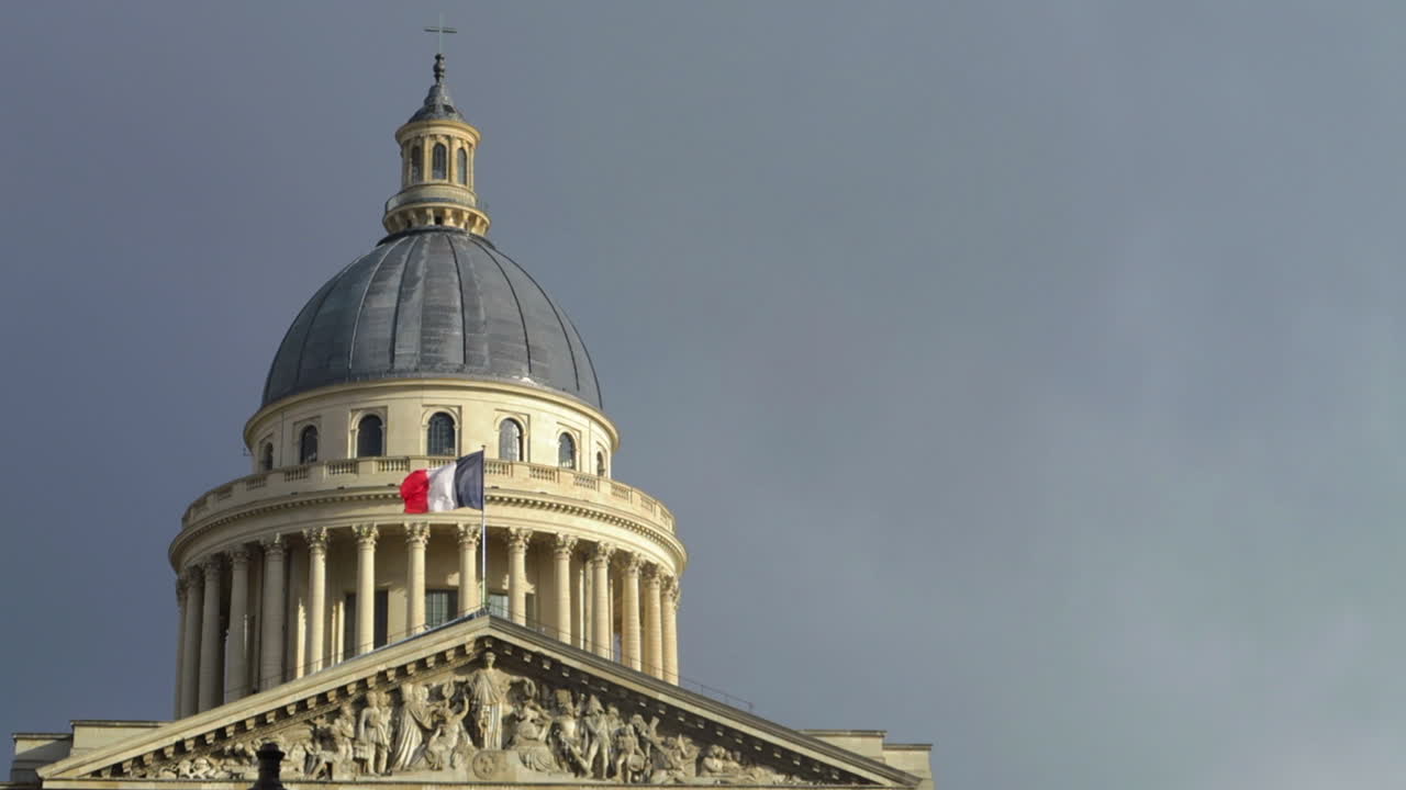 French flag blowing in wind, on the Paris Pantheon in Slow Motion. French Architecture day time
