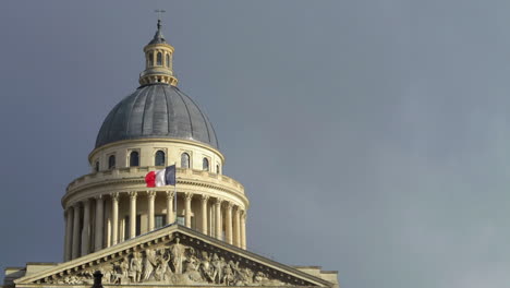 french flag blowing in wind, on the paris pantheon in slow motion. french architecture day time