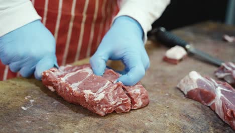 a butcher expertly slicing a rib steak